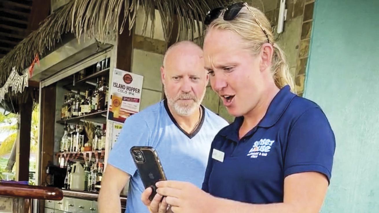 a woman looks at a phone with amazement