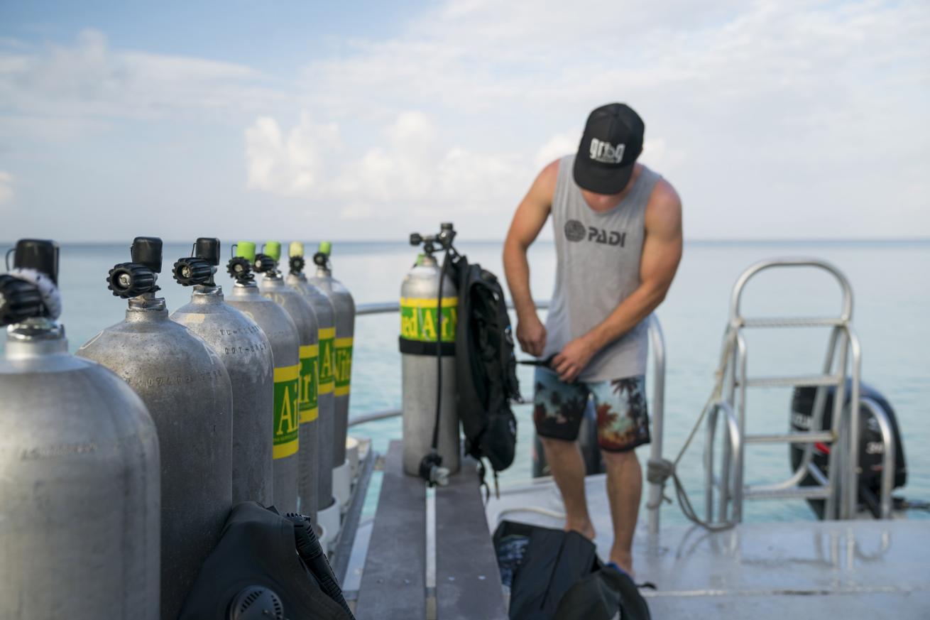 A diver setting up his nitrox tank on a boat