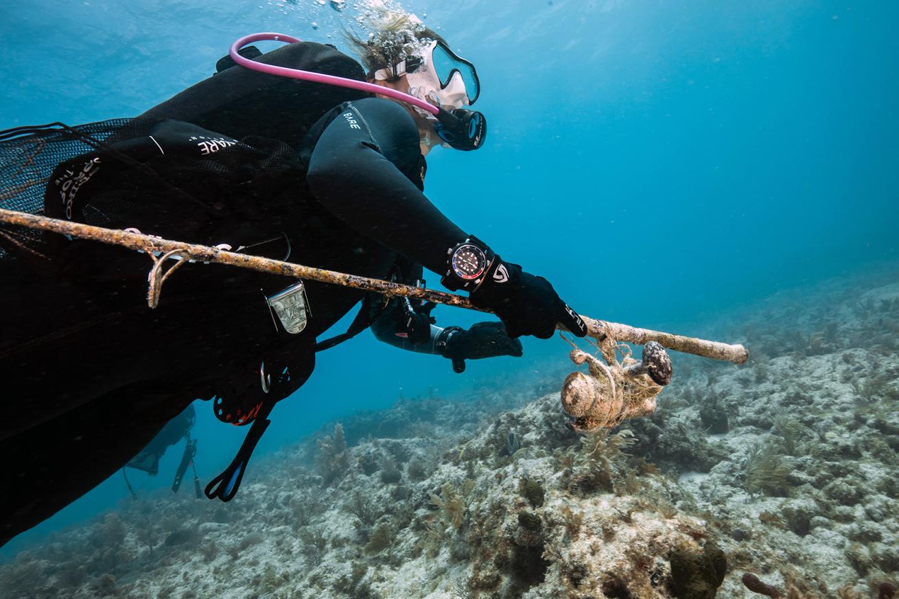 a diver carries a fishing rod that was left underwater