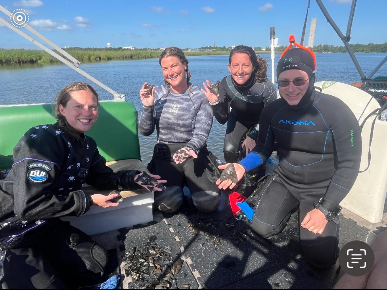 Some of the divers pose with their fossil finds aboard Captain Mark’s boat.